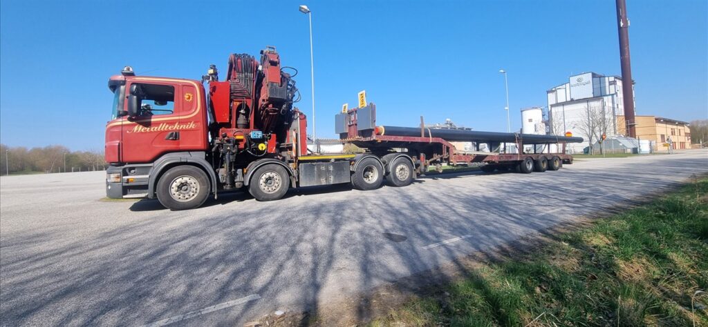 Lastbil med kran och långtrailer på väg till uppdrag